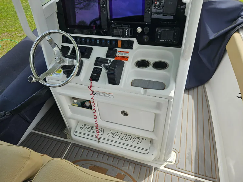 Slide: The Image of 2018 Sea Hunt Ultra 235 SE boat console with steering wheel and controls. - 7