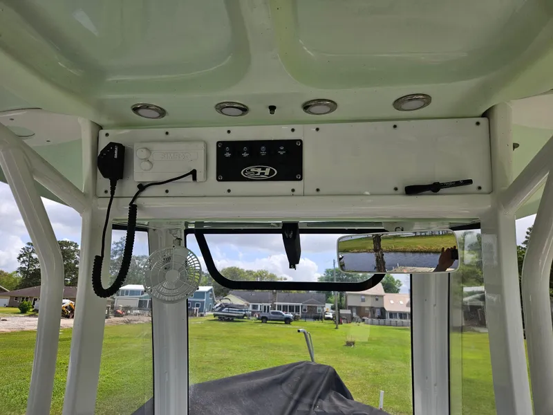 Slide: The Image of 2018 Sea Hunt Ultra 235 SE boat interior with control panel and rearview mirror. - 9