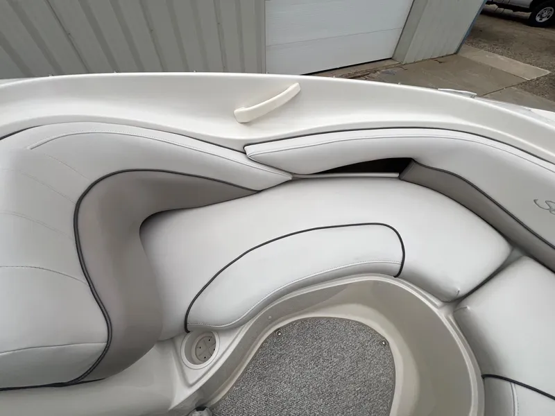 Slide: The Image of 2003 Sea Ray 200 Bow Rider interior with white cushioned seating and gray accents. - 10
