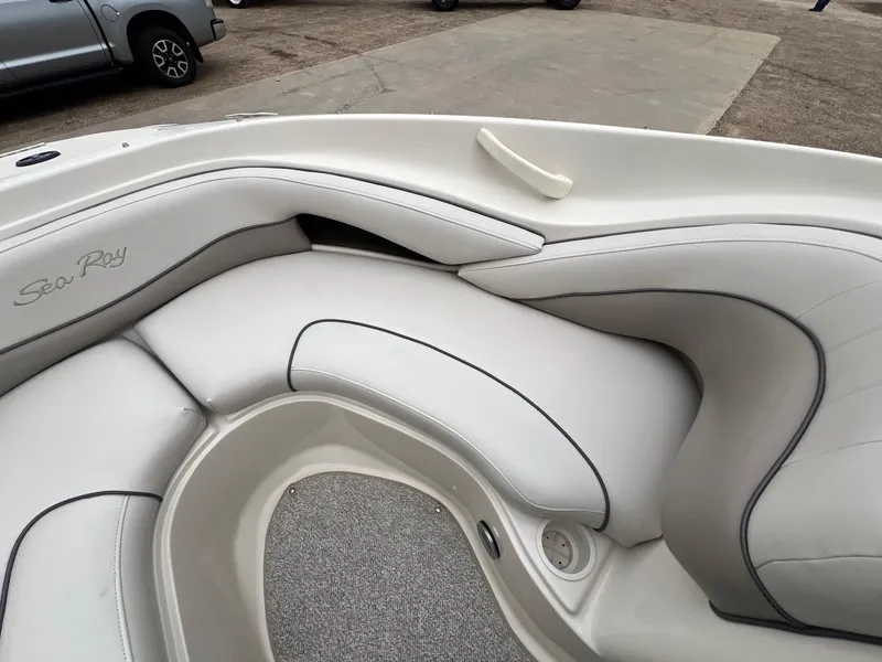 Slide: The Image of 2003 Sea Ray 200 Bow Rider interior with white cushioned seating. - 11