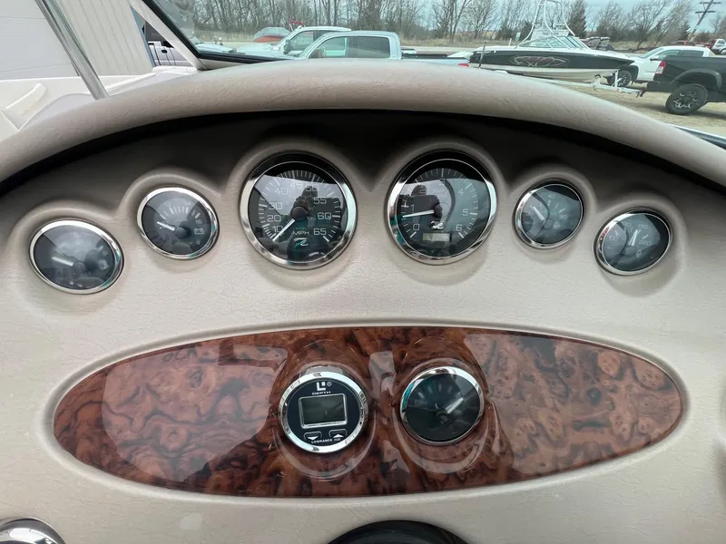 Slide: The Image of Dashboard of a 2003 Sea Ray 200 Bow Rider boat with gauges and wood paneling. - 13