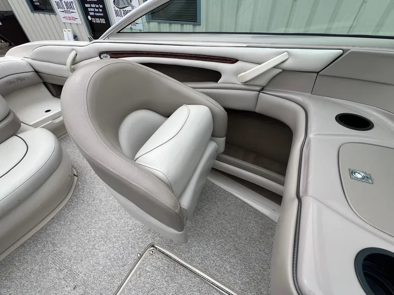 Slide: The Image of 2003 Sea Ray 200 Bow Rider interior with beige seating and cup holders. - 18