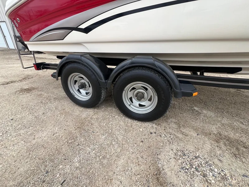 Slide: The Image of 2003 Sea Ray 200 Bow Rider on trailer, featuring dual wheels on gravel surface. - 29