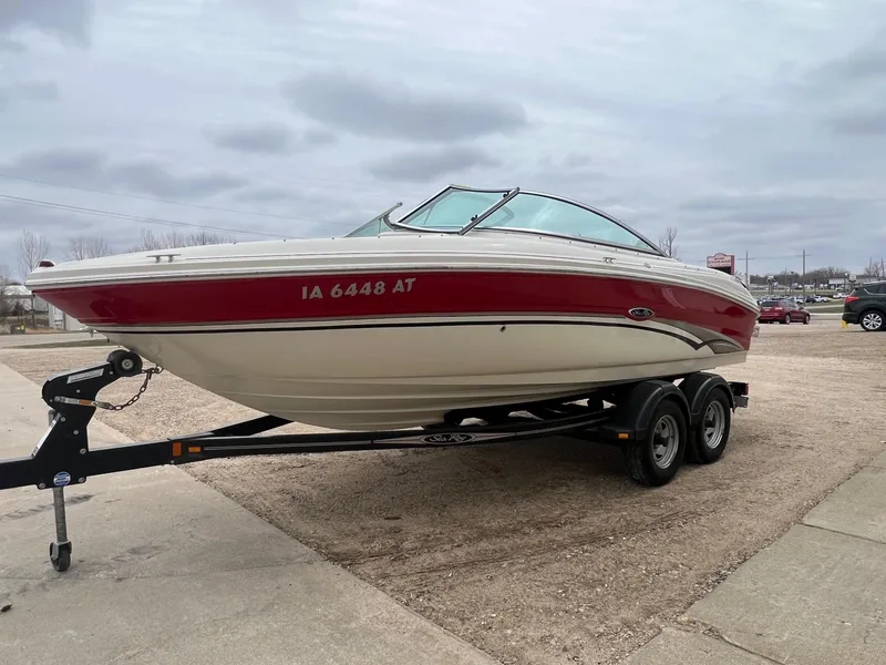 Slide: The Image of 2003 Sea Ray 200 Bow Rider boat on trailer, parked outdoors under cloudy sky. - 4