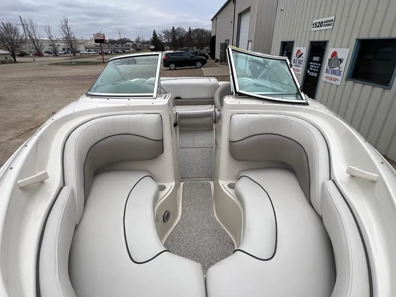 Slide: The Image of 2003 Sea Ray 200 Bow Rider boat interior with white seating and open windshield. - 5