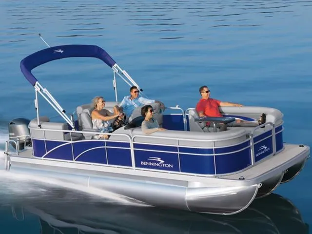 Slide: The Image of 2023 Bennington 188 SVL pontoon boat cruising on calm water with passengers. - 1