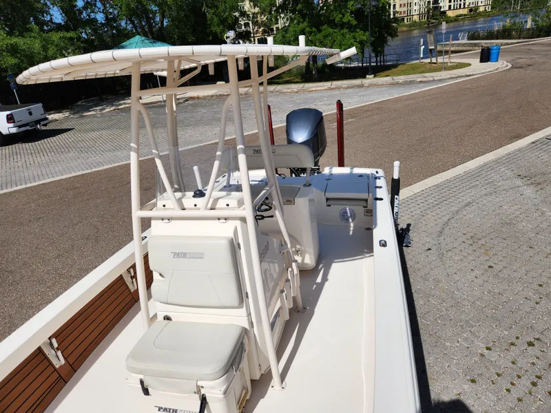 Slide: The Image of 2018 Pathfinder 2500 Hybrid boat with T-top and seating, parked on a paved area. - 43