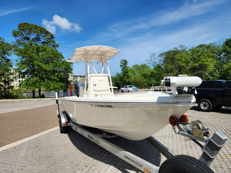 Slide: The Image of 2018 Pathfinder 2500 Hybrid boat on trailer, parked outdoors under a clear blue sky. - 6