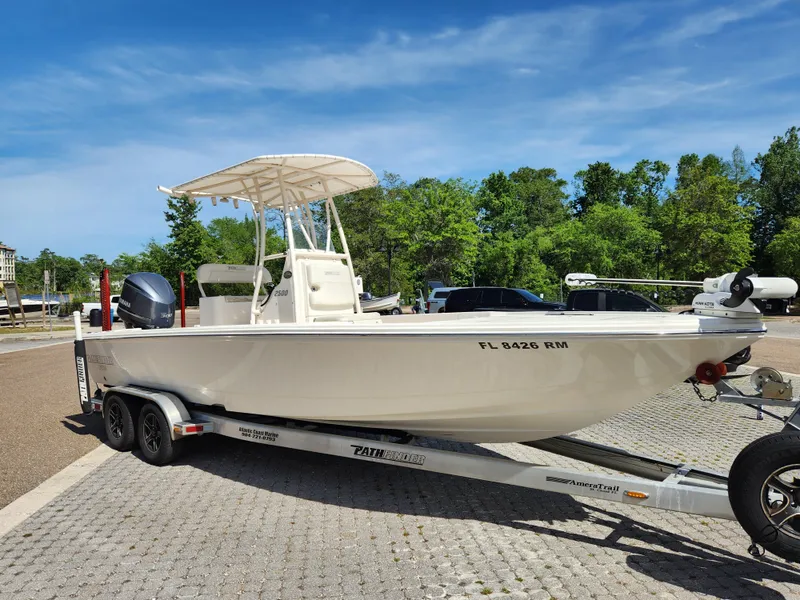 Slide: The Image of 2018 Pathfinder 2500 Hybrid boat on trailer, parked outdoors under clear sky. - 7