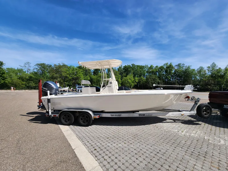 Slide: The Image of 2018 Pathfinder 2500 Hybrid boat on trailer in parking lot under clear blue sky. - 8