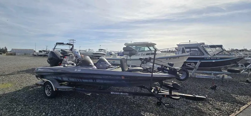 Slide: The Image of 2003 Triton TR-20 boat on trailer in a marina with other boats. - 3