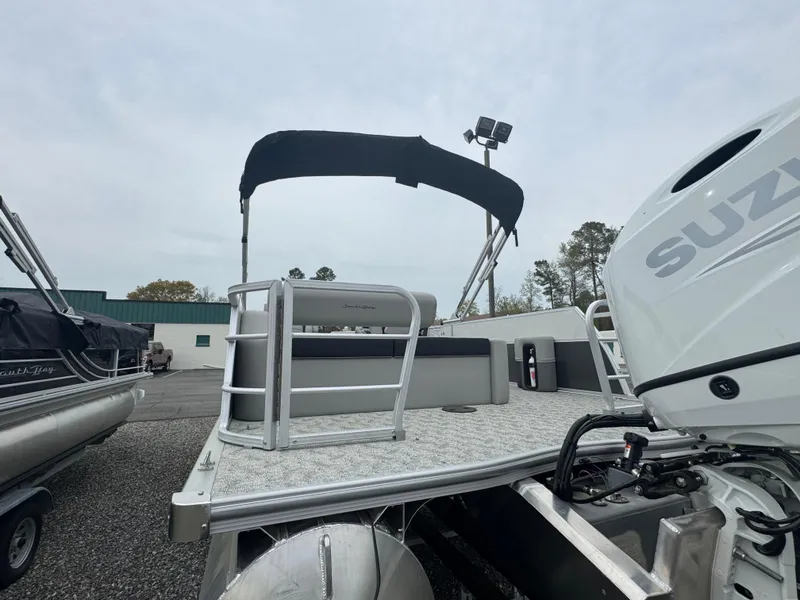 Slide: The Image of 2025 South Bay 224UL pontoon boat with Suzuki engine, docked outdoors. - 12