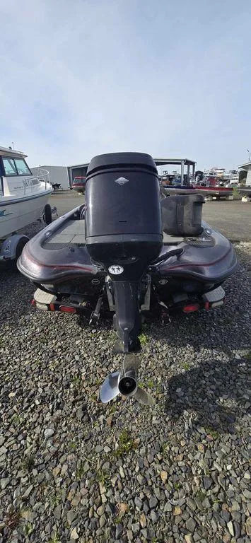 Slide: The Image of 2002 Arima Sea Ranger 19 boat with outboard motor, parked on gravel. - 2
