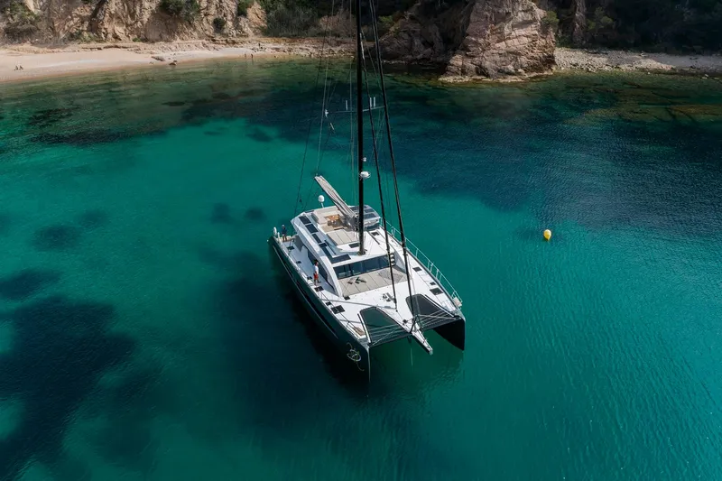 Slide: The Image of Luxury Privilege Signature 580 catamaran anchored in clear turquoise waters, 2025 model. - 1