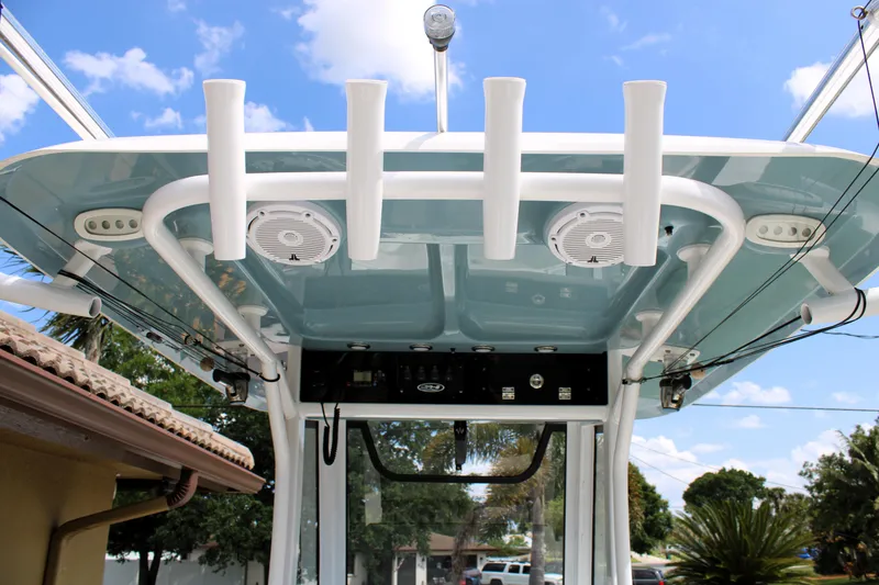 Slide: The Image of 2022 Sea Hunt Gamefish 27 T-top with rod holders and speakers under blue sky. - 30