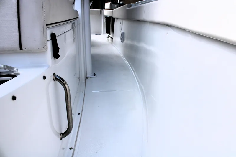Slide: The Image of 2022 Sea Hunt Gamefish 27 boat interior, featuring a sleek white walkway and seating. - 37