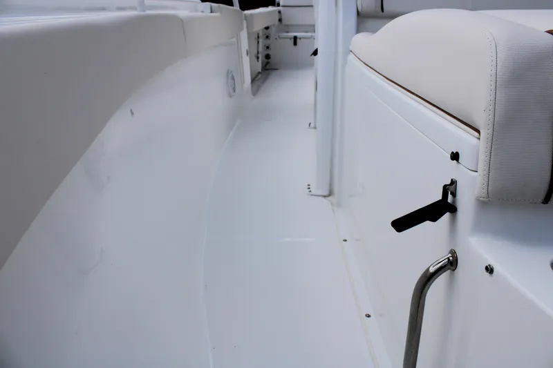 Slide: The Image of 2022 Sea Hunt Gamefish 27 interior with coffin box, featuring sleek white seating and storage. - 38