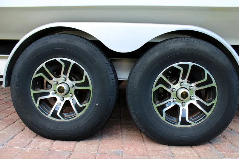 Slide: The Image of Trailer wheels of 2022 Sea Hunt Gamefish 27 with Coffin Box on brick pavement. - 45