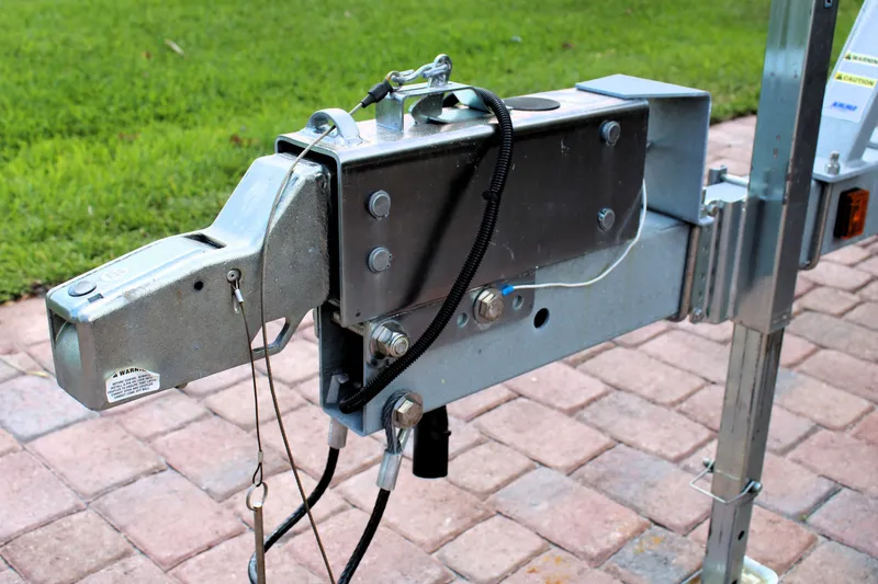 Slide: The Image of Trailer hitch of a 2022 Sea Hunt Gamefish 27 with Coffin Box on brick pavement. - 46