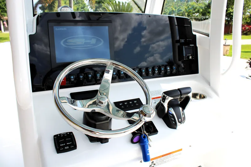 Slide: The Image of 2022 Sea Hunt Gamefish 27 dashboard with steering wheel and controls. - 9
