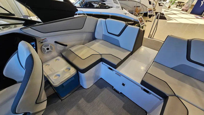 Slide: The Image of 2023 Yamaha Boats AR220 interior with gray seating and built-in cooler. - 10