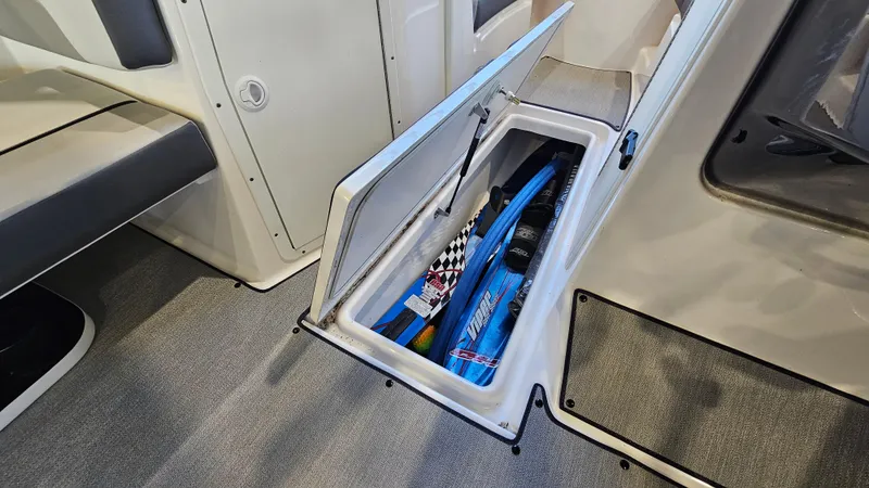 Slide: The Image of 2023 Yamaha Boats AR220 storage compartment with water sports equipment. - 22