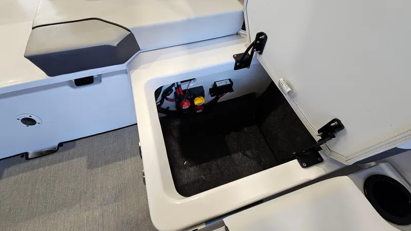 Slide: The Image of 2023 Yamaha Boats AR220 storage compartment with open hatch, showcasing interior details. - 24