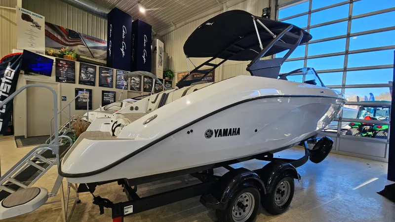Slide: The Image of 2023 Yamaha Boats AR220 in showroom, sleek white design on trailer. - 3