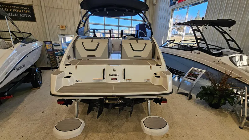 Slide: The Image of 2023 Yamaha Boats AR220 displayed in a showroom, rear view with seating and swim platform. - 5