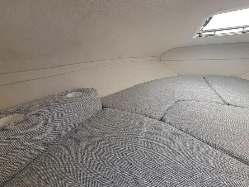 Slide: The Image of 2004 Glastron GS209 cabin interior with cushioned seating and small window. - 11