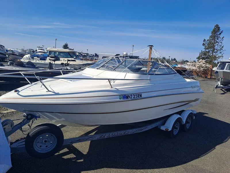 Slide: The Image of 2004 Glastron GS209 boat on trailer in marina parking lot under clear blue sky. - 12