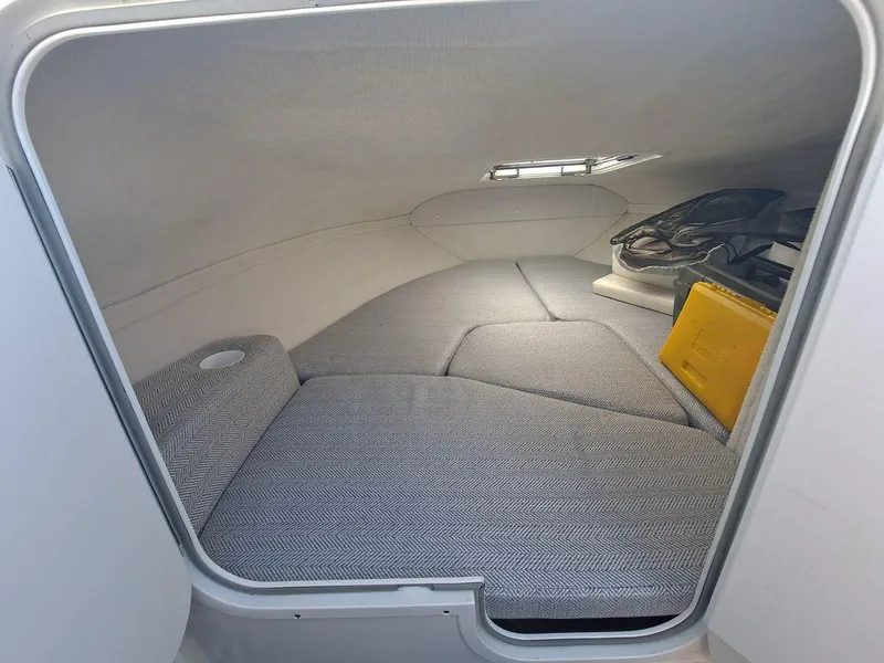 Slide: The Image of 2004 Glastron GS209 cabin interior with cushioned seating and small window. - 4