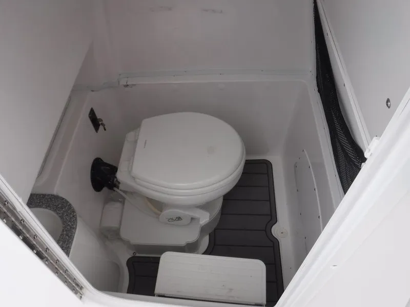 Slide: The Image of 2025 NauticStar 292 Legacy boat bathroom with compact toilet and modern design. - 20