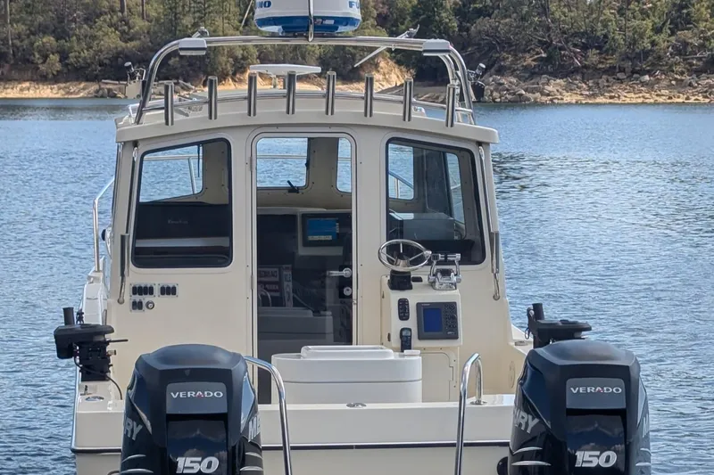 Slide: The Image of 2008 C-Dory 255 TOMCAT boat with dual Verado 150 engines on a serene lake. - 13