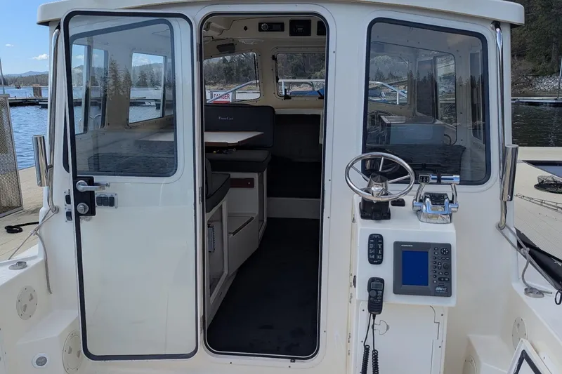 Slide: The Image of 2008 C-Dory 255 TOMCAT boat interior with steering wheel and navigation equipment. - 14