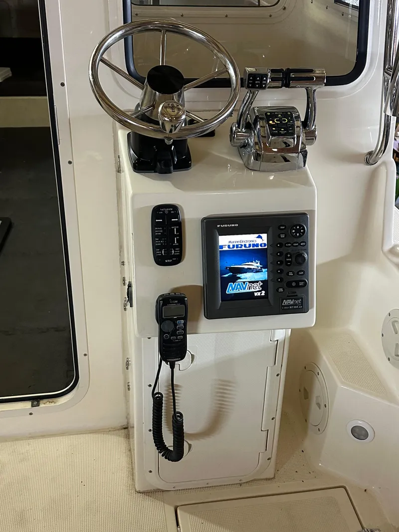 Slide: The Image of 2008 C-Dory 255 TOMCAT helm with steering wheel, controls, and navigation display. - 15