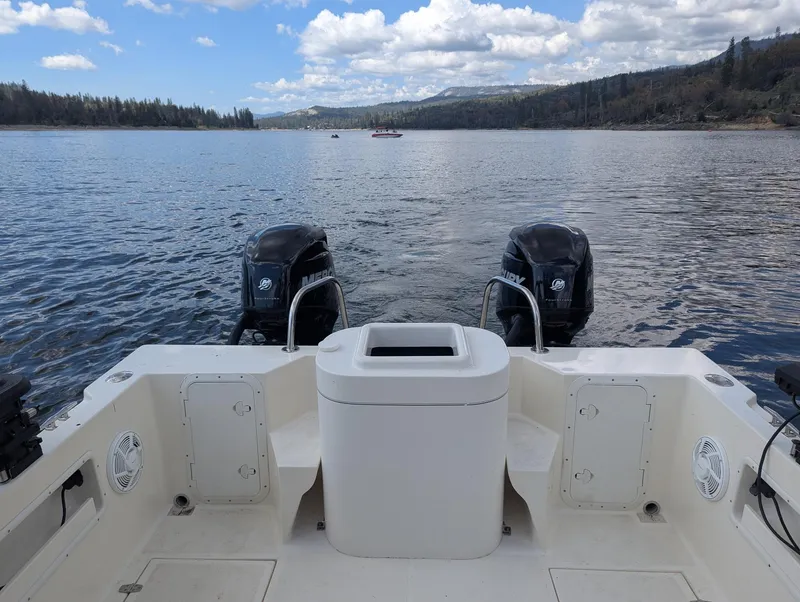 Slide: The Image of 2008 C-Dory 255 TOMCAT boat with dual engines on a serene lake. - 16
