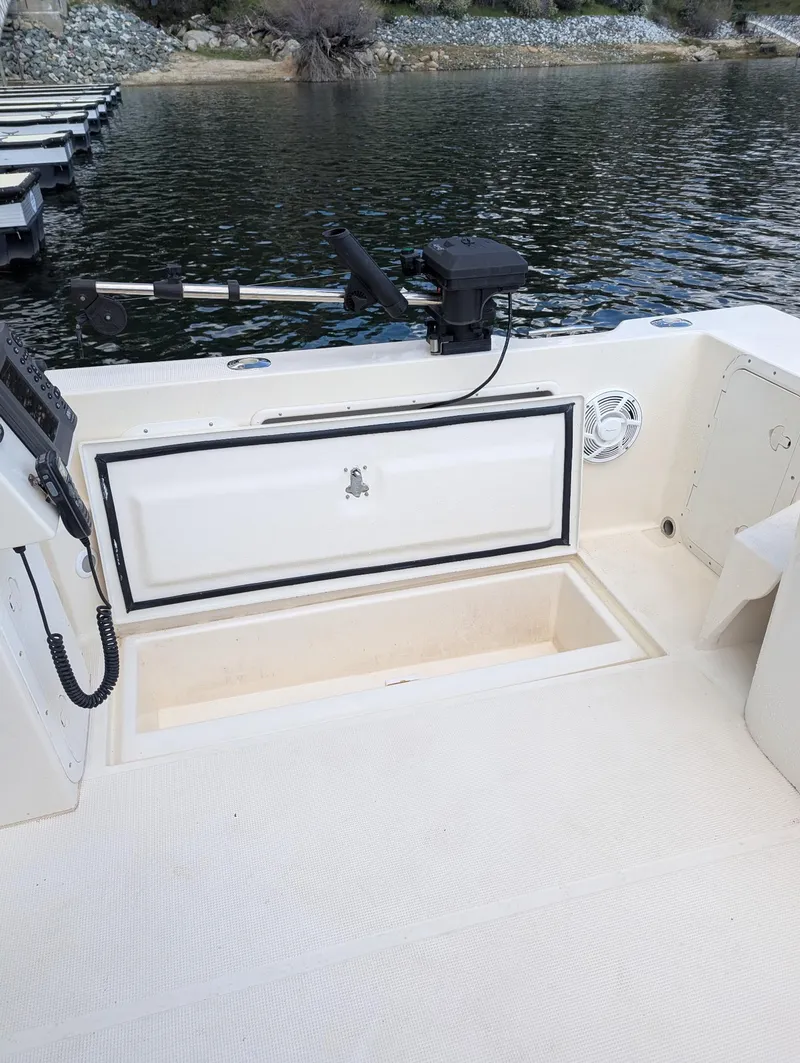 Slide: The Image of 2008 C-Dory 255 TOMCAT boat deck with storage compartment and fishing equipment. - 17