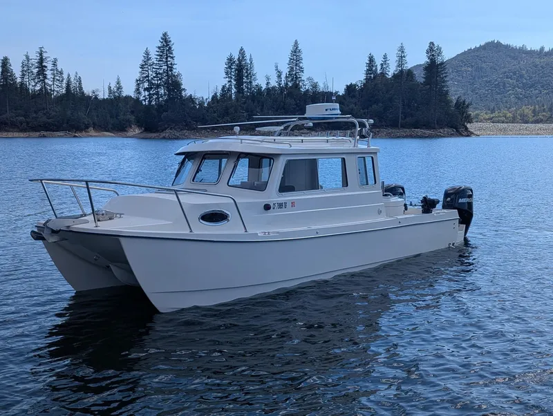 Slide: The Image of 2008 C-Dory 255 TOMCAT boat on calm lake with forested shoreline. - 2