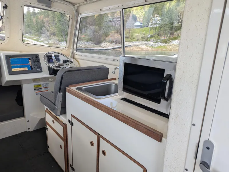 Slide: The Image of 2008 C-Dory 255 TOMCAT interior with helm, sink, and microwave. - 21