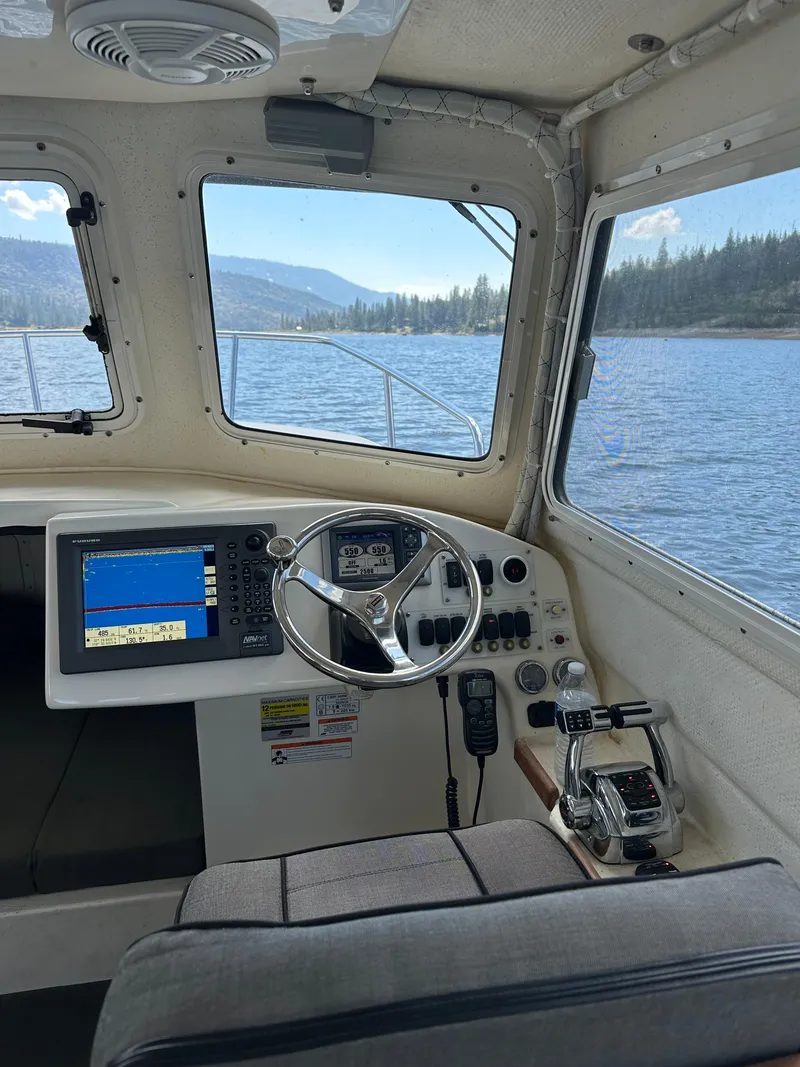 Slide: The Image of Interior view of 2008 C-Dory 255 TOMCAT boat with steering wheel and navigation system. - 24