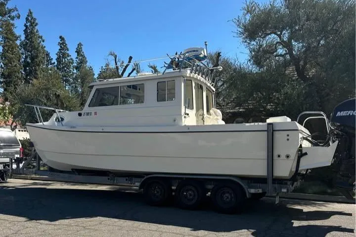 Slide: The Image of 2008 C-Dory 255 TOMCAT boat on trailer, parked outdoors. - 7