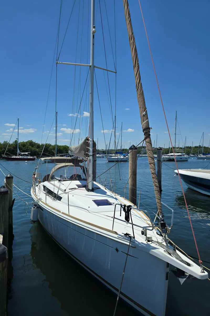 Slide: The Image of 2017 Jeanneau Sun Odyssey 389 sailboat docked in a marina under clear blue skies. - 10