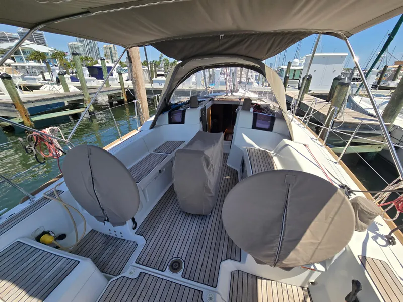 Slide: The Image of 2017 Jeanneau Sun Odyssey 389 sailboat cockpit with covered steering wheels at marina. - 25