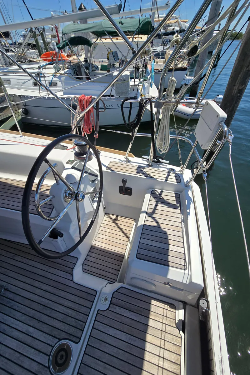 Slide: The Image of 2017 Jeanneau Sun Odyssey 389 sailboat cockpit with steering wheel, docked at marina. - 29