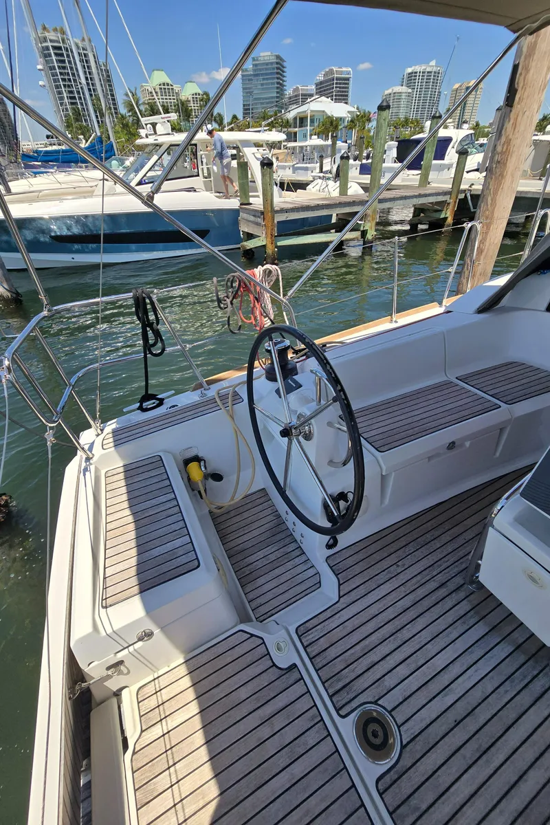 Slide: The Image of 2017 Jeanneau Sun Odyssey 389 sailboat cockpit with wheel, docked in marina. - 30