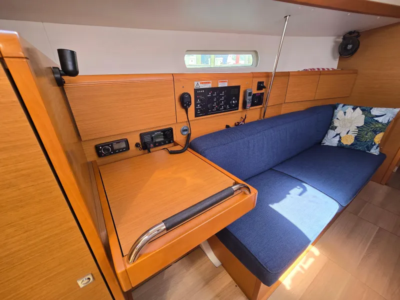 Slide: The Image of 2017 Jeanneau Sun Odyssey 389 interior with navigation station and blue cushioned seating. - 32