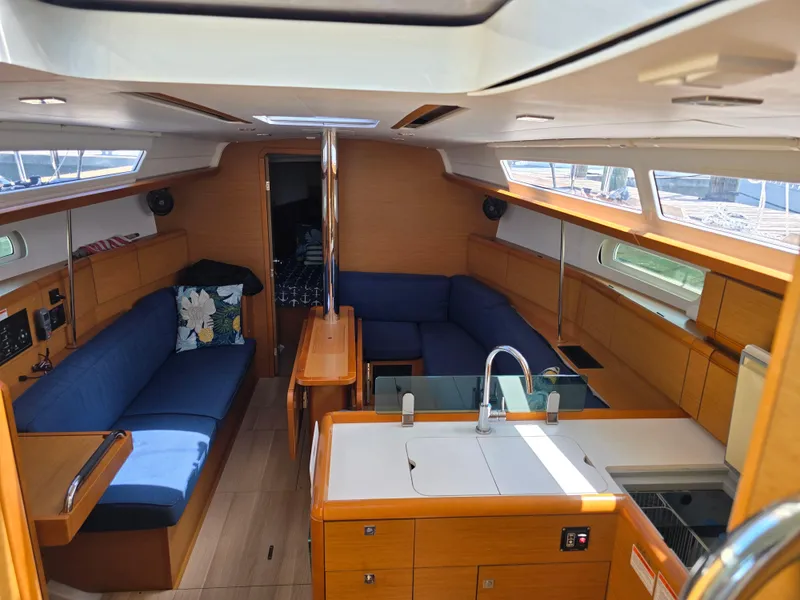 Slide: The Image of Interior of 2017 Jeanneau Sun Odyssey 389 sailboat with blue seating and wooden finishes. - 40
