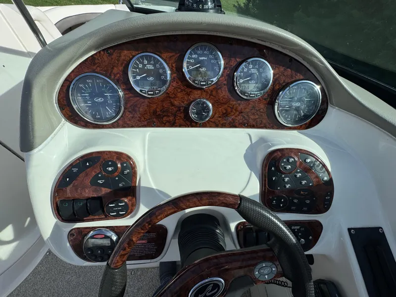 Slide: The Image of 2006 Sea Ray 290 SLX dashboard with wood grain finish and multiple gauges. - 3