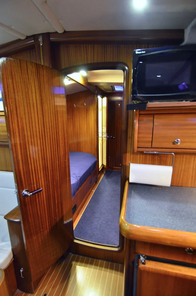 Slide: The Image of Interior of a 2003 Bavaria 49 yacht with wooden cabinetry and cozy sleeping quarters. - 10